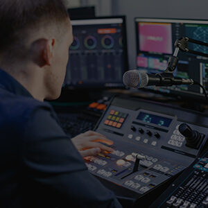 Media production student operating audio and video editing equipment