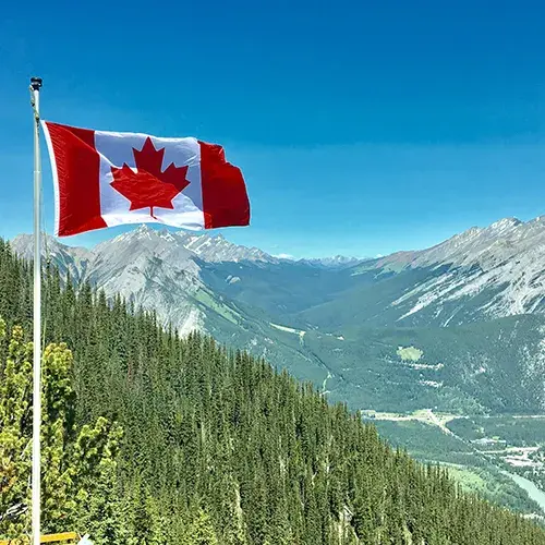 Study in Canada surrounded by the beauty of the Canadian flag and mountain landscapes