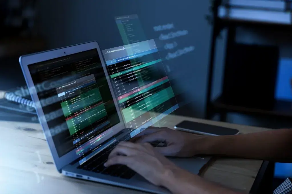 Student studying information technology overseas while programming on a laptop